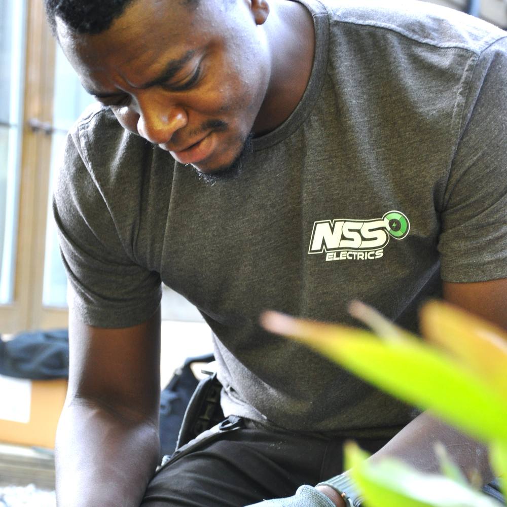 Nash, founder and lead electrician at NSS Electrics, working on site in branded workwear